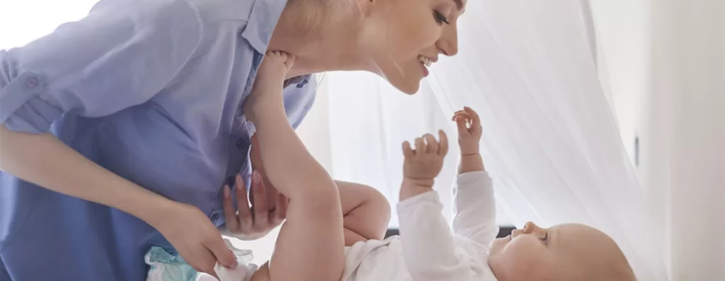 Bebê no trocador acompanhado de sua mãe. 